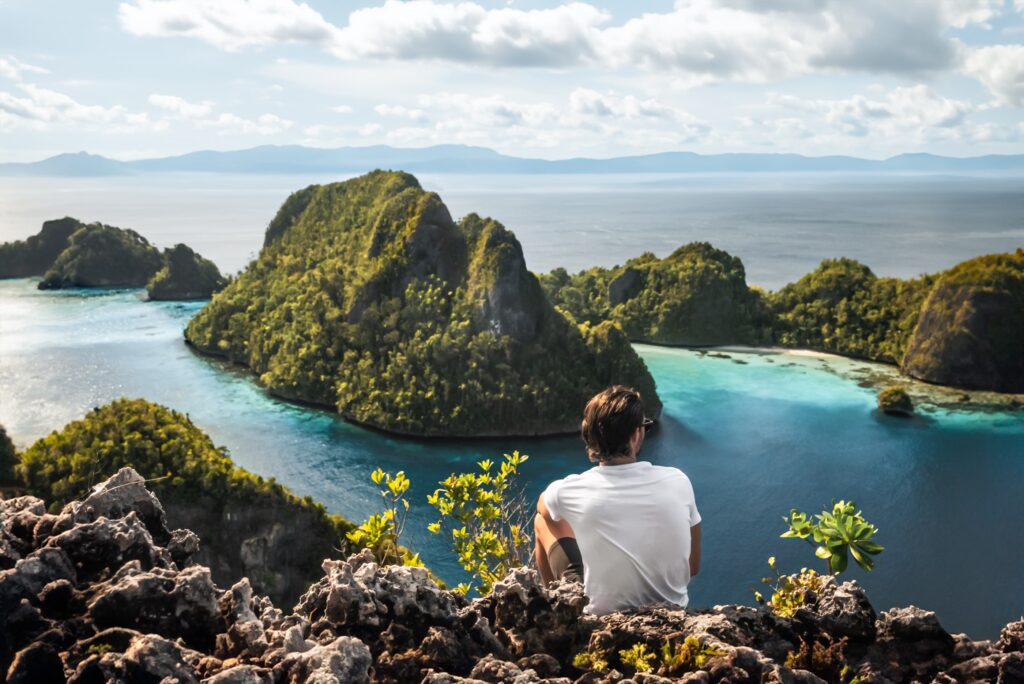 Hikers admiring panoramic view over Wayag’s karst islands in Raja Ampat
